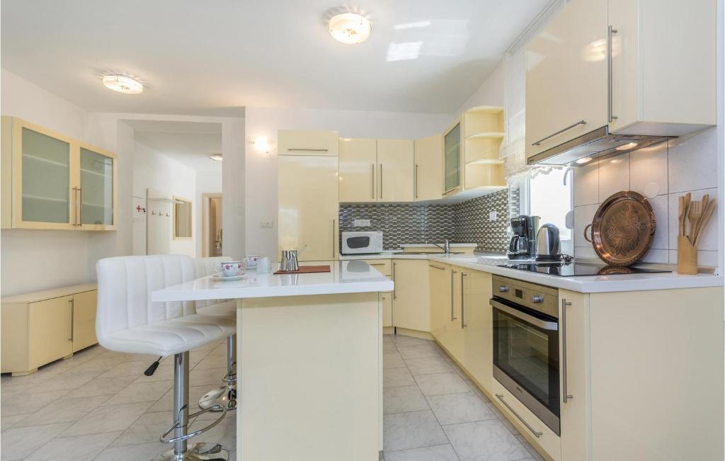duża kuchnia z białymi szafkami i blatem w obiekcie Four-Bedroom Holiday Home In Perci w mieście Perkovići
