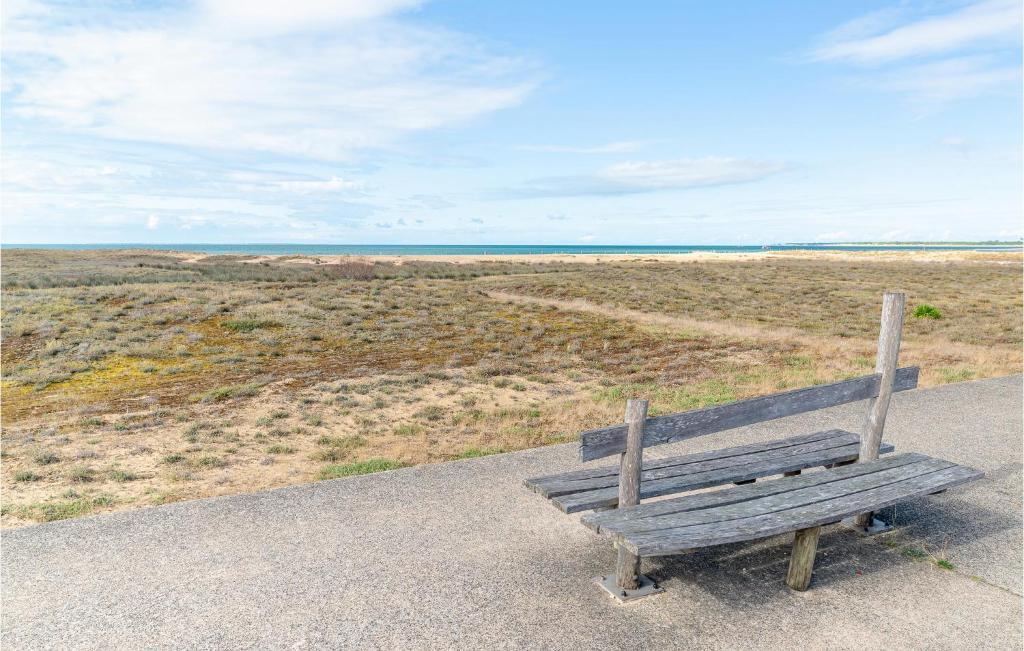 a wooden bench sitting on the side of a field at Awesome Home In La Faute Sur Mer in La Faute-sur-Mer