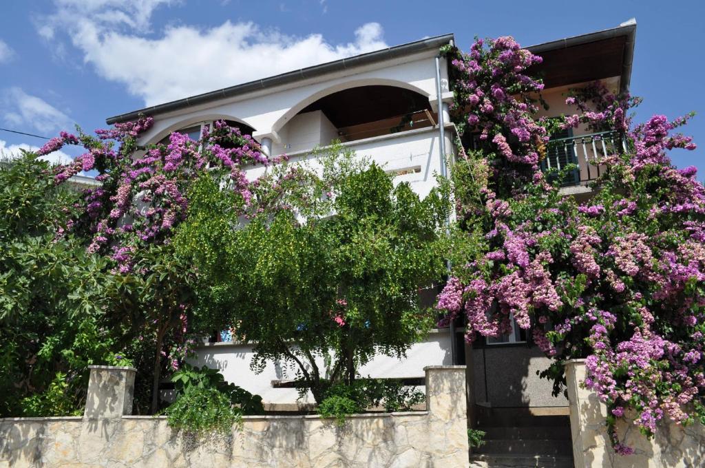 een gebouw met bloemen aan de zijkant bij Apartments Petar Maksan in Pakoštane