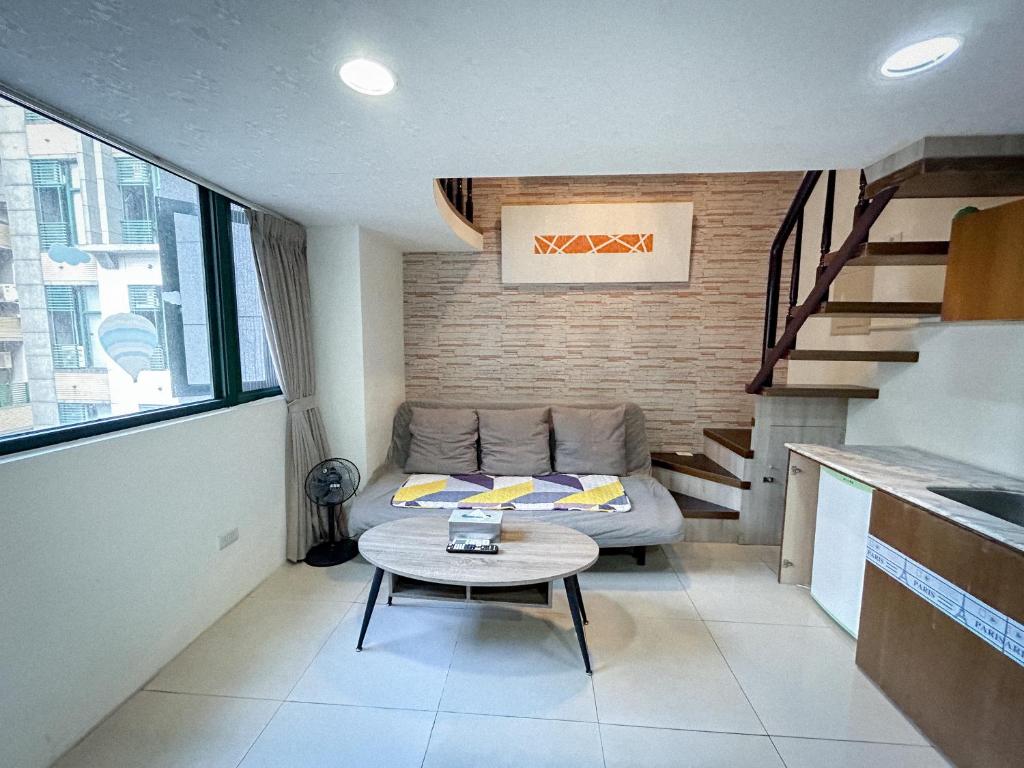 una sala de estar con un sofá y una mesa en 小牧湯泉民宿, en Jiaoxi