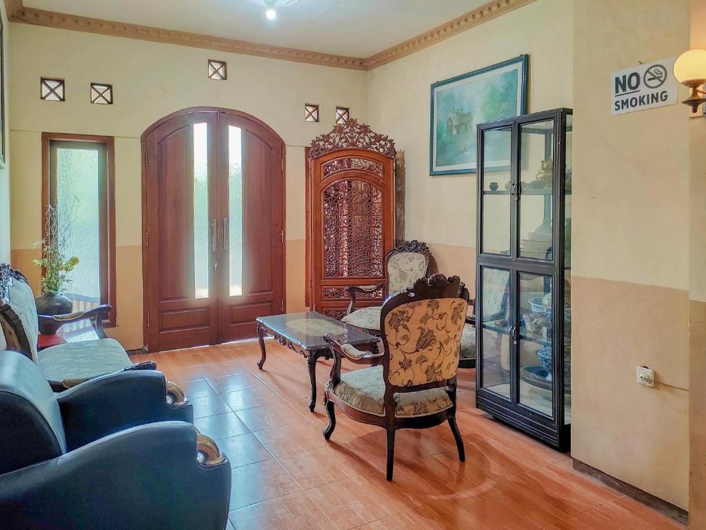 a living room with chairs and a table at RedDoorz Near Alun Alun Kota Wisata Batu in Batu