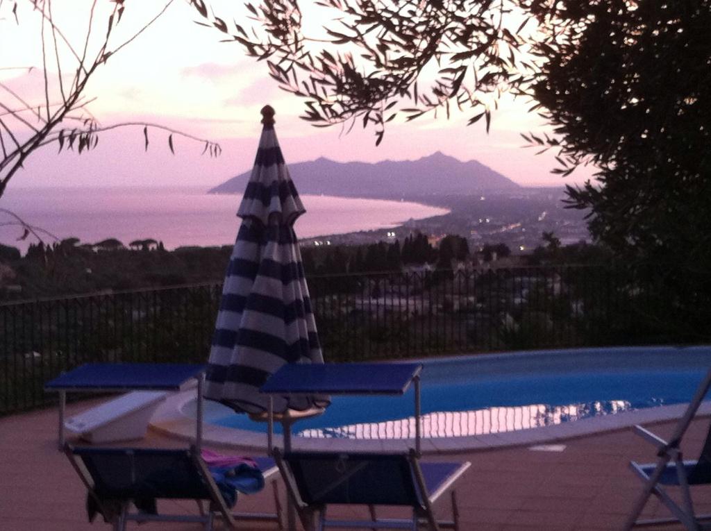 - une table et des chaises à côté de la piscine dans l'établissement Villa "Ai Galli", à Terracine
