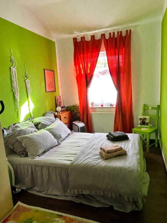 ein Schlafzimmer mit einem Bett mit roten Vorhängen und einem Fenster in der Unterkunft Ferienwohnung HAPPYHOME Bahnhofnah gemütlich familiär in Arnstadt