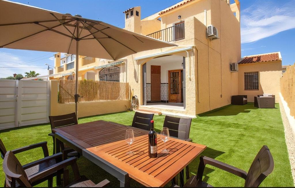 una mesa de madera con una sombrilla en un patio en Bungalow Colibrí, en Torrevieja