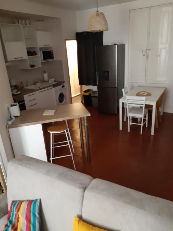 un salon avec un canapé blanc et une cuisine dans l'établissement T2 climatisé en centre ville, à Perpignan