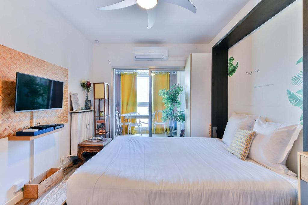 - une chambre avec un grand lit et une télévision dans l'établissement LE FESTIF splendide studio avec loggia au Carré d'Or, une joie spéciale pour deux, à Cannes