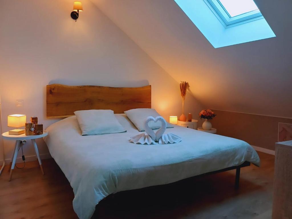 a bedroom with a large bed with a skylight at Gîte "Le Sablon" à Unchair - Appartement de charme & prestations bien-être - A 20 mn de Reims centre in Unchair