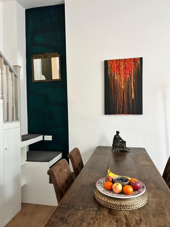 a dining room table with a bowl of fruit on it at Casa Rosa, Notting Hill in London