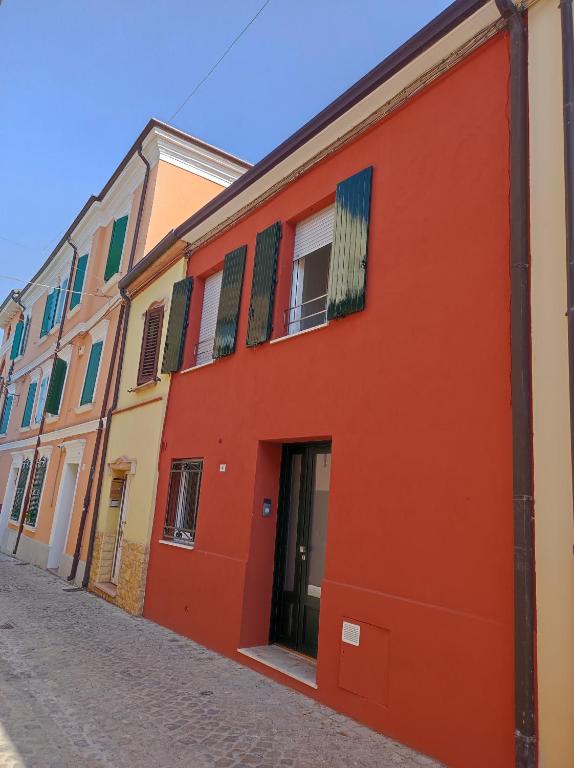 a red building on the side of a street at Casa delle zie Savoretti in San Clemente