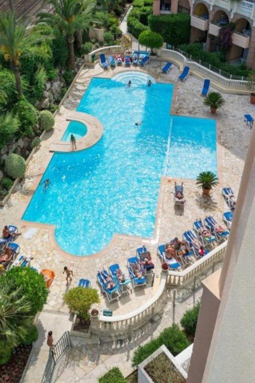 Elle offre une vue sur la grande piscine bordée de chaises. dans l'établissement Verrerie beach, à Cannes