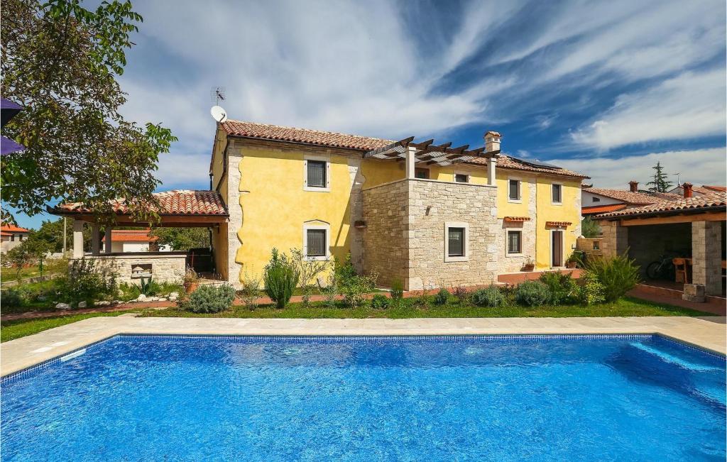 a house with a swimming pool in front of a house at Villa Ive in Orbanići
