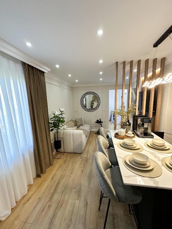 a living room with a large table and chairs at Porcelain Apartment in Rădăuţi