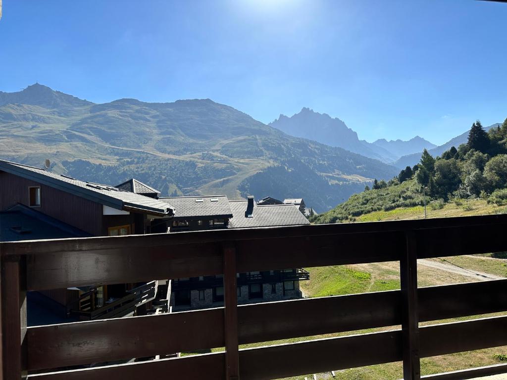 une maison sur une colline avec des montagnes en arrière-plan dans l'établissement Appart 2 pièces 6p - Pied des pistes avec vue - Parking - Mottaret, à Les Allues