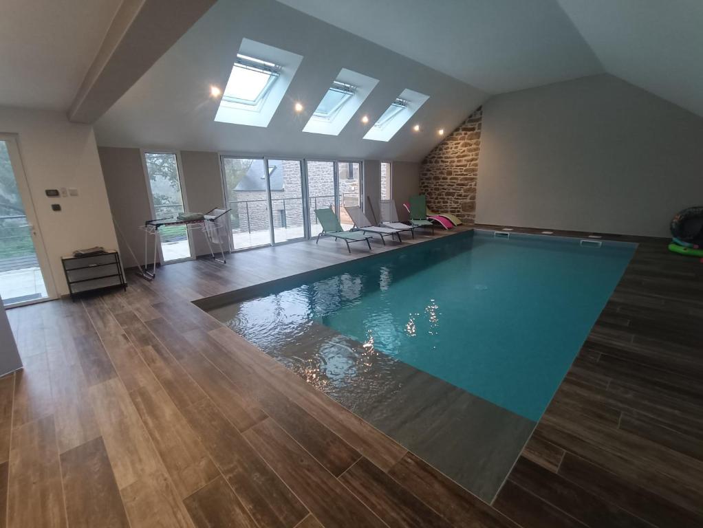 a large swimming pool in a room with wooden floors at le petit moulin de Kerloroc in Ploudalmézeau