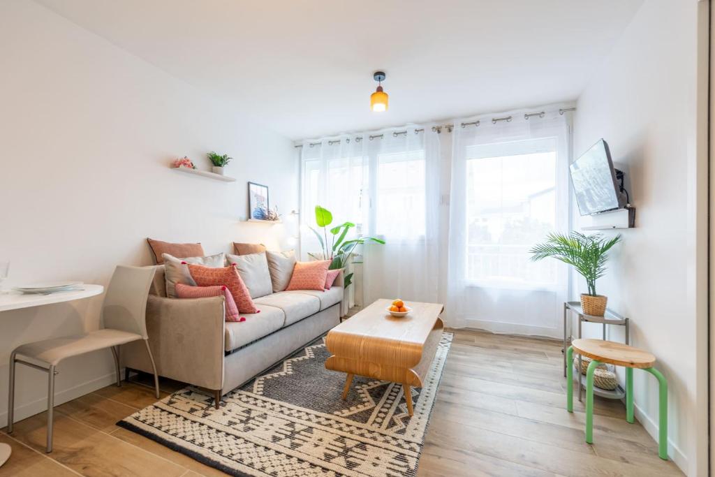 アヌシーにあるLac Pershing - Appartement confortable à deux pas du lacのソファとテーブルのあるリビングルーム
