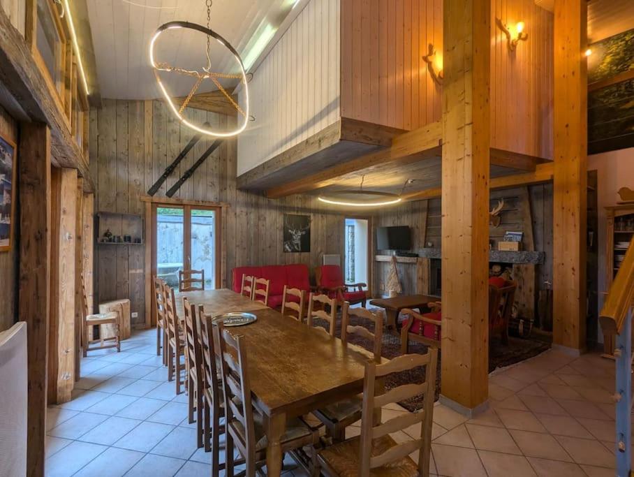 une salle à manger avec une grande table et des chaises en bois dans l'établissement Les Jonquilles - 12 pers - pleine nature, à Xonrupt-Longemer