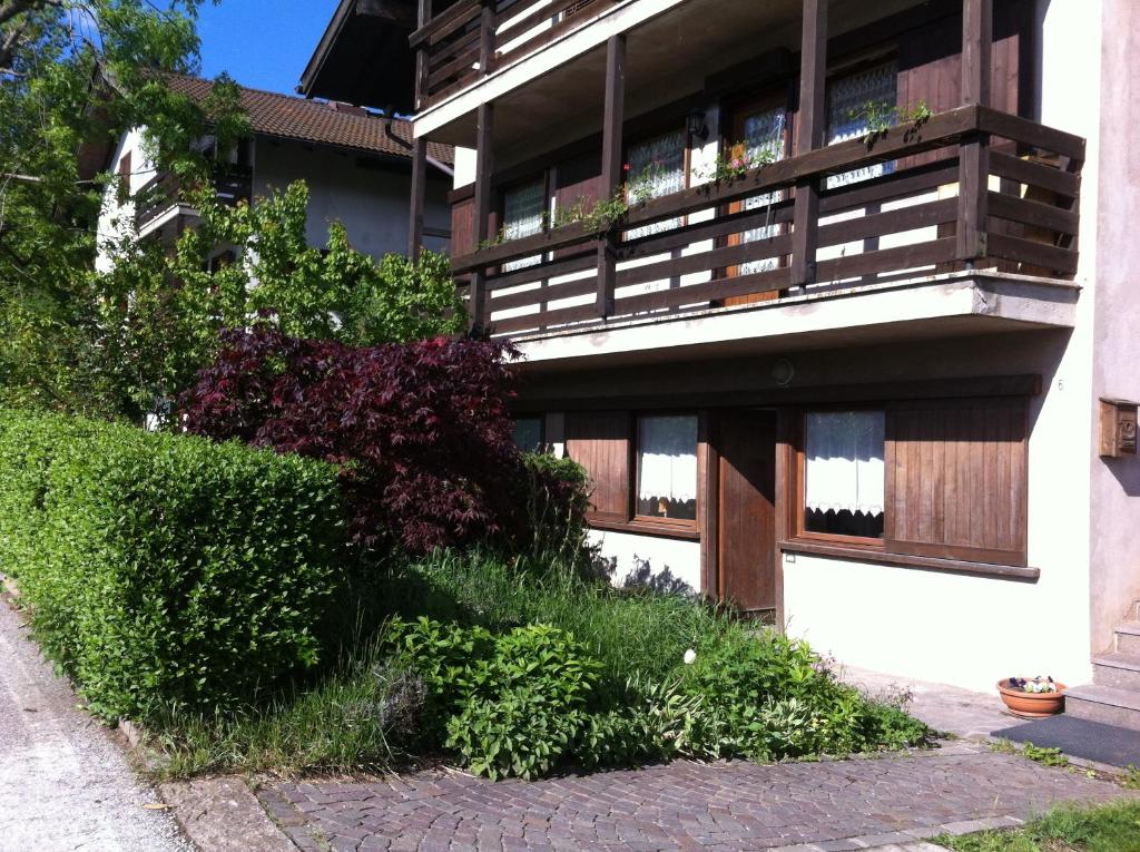 ein Gebäude mit einem Balkon und einigen Büschen in der Unterkunft Almida in Castello di Fiemme
