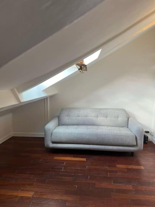 - un canapé bleu dans une chambre avec plafond dans l'établissement Au Cœur de Montmartre, à Paris
