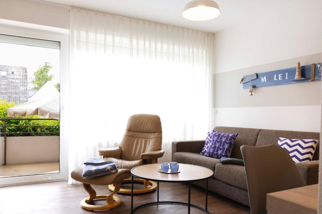 a living room with a couch and a table at DKK1c Ferienwohnung Mole 1 in Niendorf