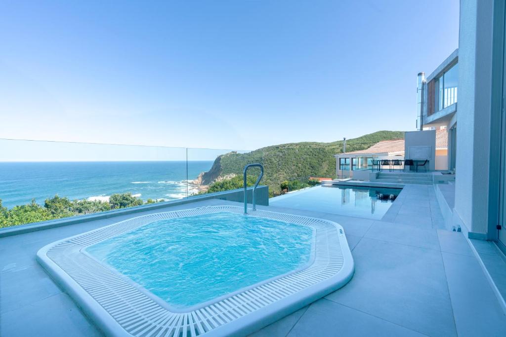 una piscina en la parte superior de una casa con el océano en Pure Emotions Luxury Villa, en Knysna