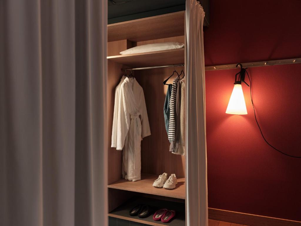 a walk in closet with a red wall and a light at Casa Camper Berlin in Berlin