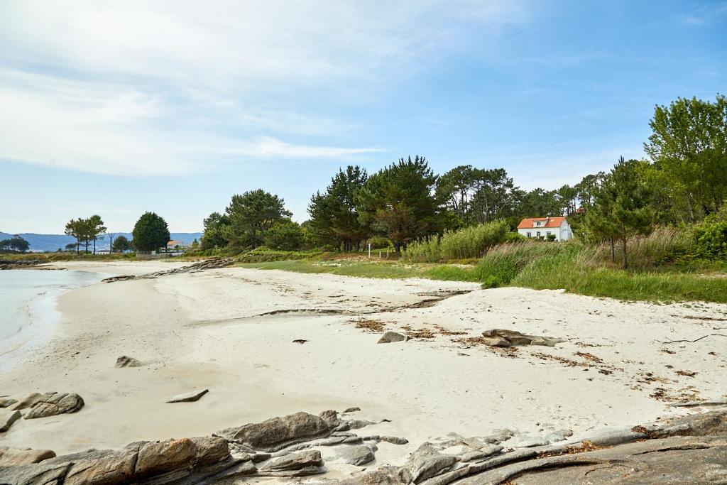 a sandy beach with a house in the background at La Casita de la Playa Escondida in Tal