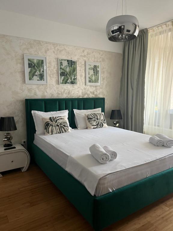 a bedroom with a green bed with two towels on it at Apartment near IPJ IASI Copou in Iaşi