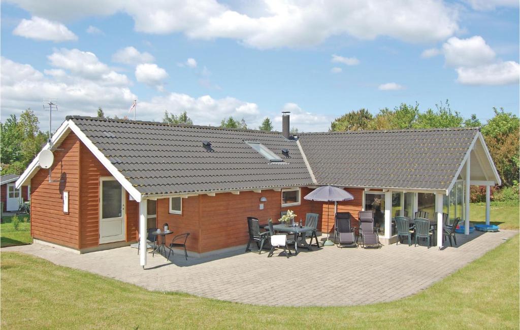 a house with a deck and a patio at Holiday Home Bogo By 34 With Hot Tub in Bogø By