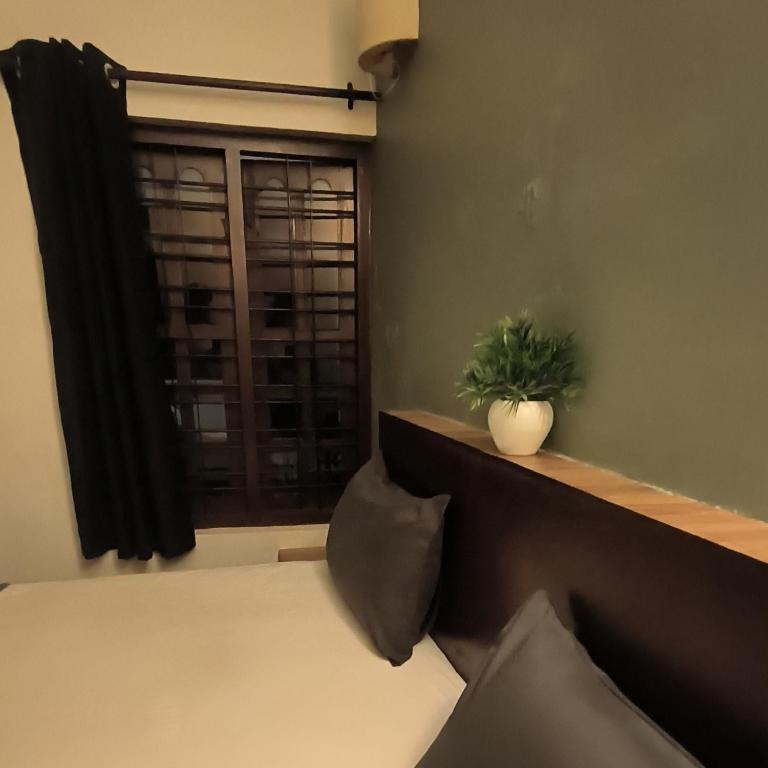 a bedroom with a window with a potted plant at Mad about Coco Yoga & Beach Retreat in Varkala