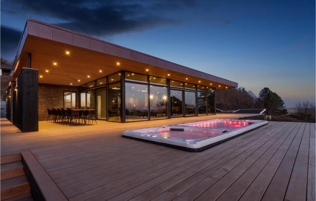 a large house with a deck with a hot tub at Awesome Home In Knebel With Sauna in Knebel