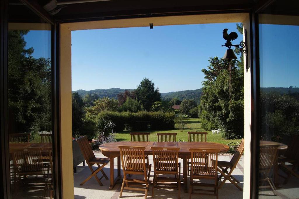 une table et des chaises en bois sur une terrasse dans l'établissement Le monteil, à Calviac