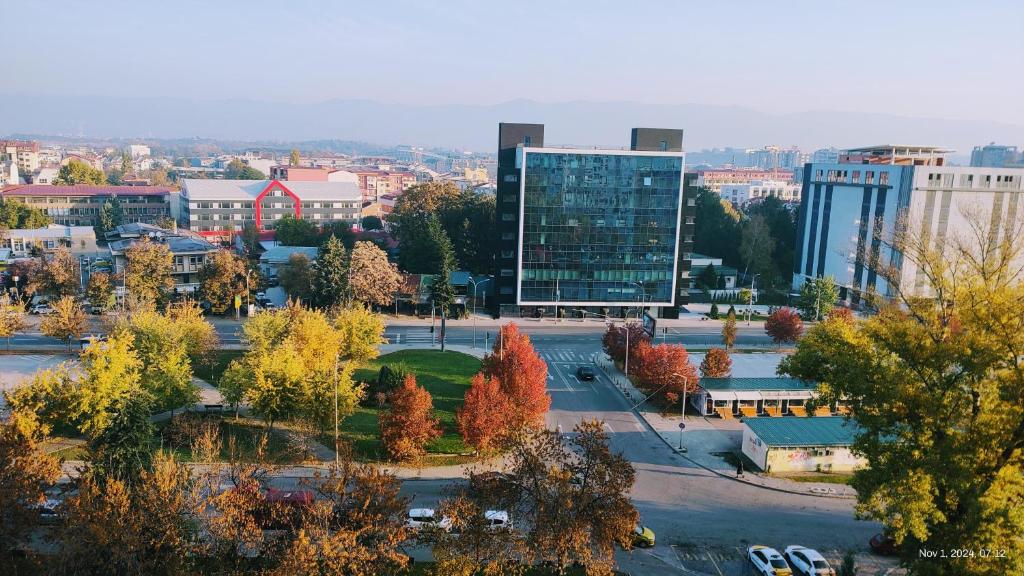 a city with a tall glass building and trees at View in Skopje