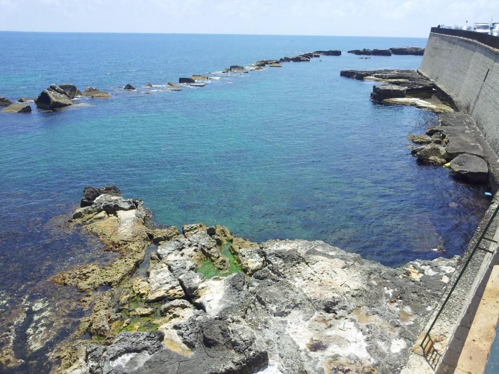 a view of the ocean from a cliff at Tolomei House Holidays Sea View in Siracusa