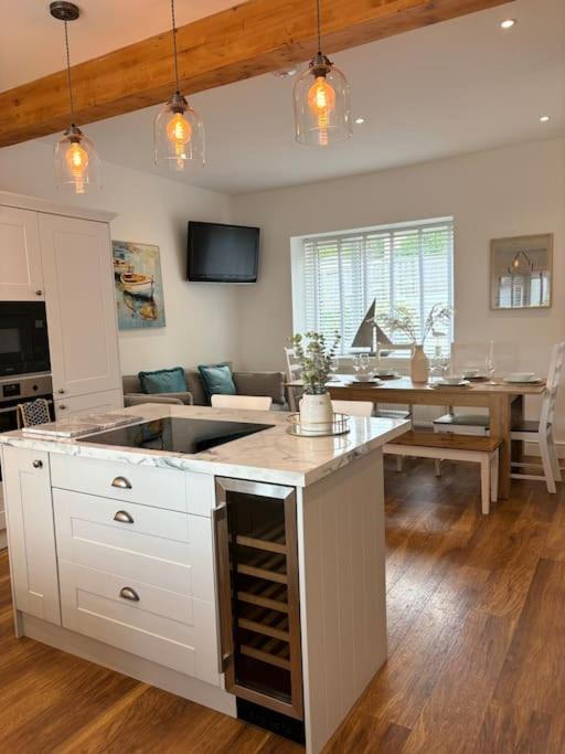 a kitchen with a sink and a living room at House in the heart of Pembroke in Pembroke