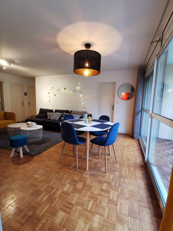 Una sala de estar con una mesa y sillas y un sofá. en Nantes RENAUDIERE - Proche Parc Expo Stade Beaujoire - Wifi - Parking - Tramway bus, en Nantes