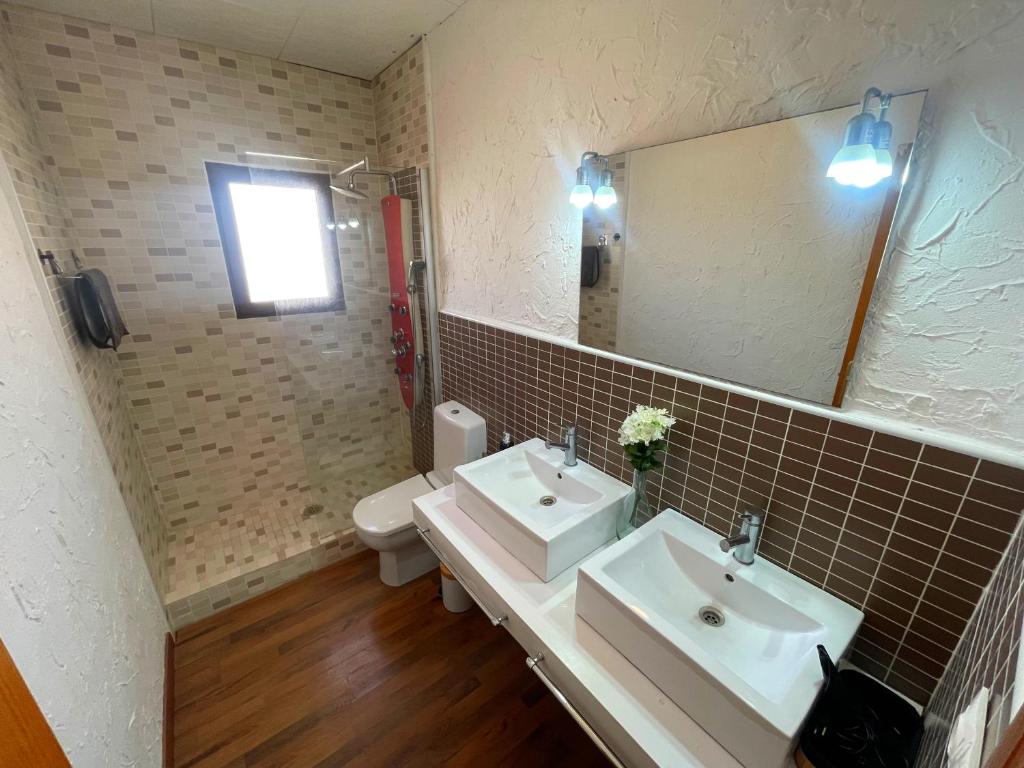 a bathroom with two sinks and a mirror and a toilet at Villa Richmond in Gran Alacant