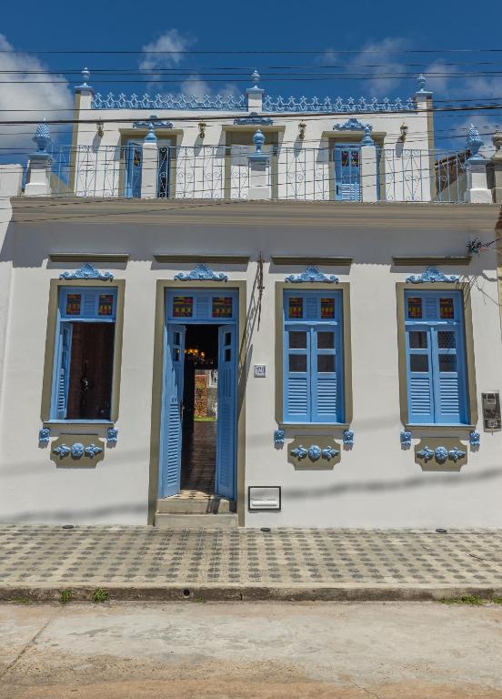 un edificio blanco con ventanas azules y una puerta en Casa Rualisa, en Belmonte