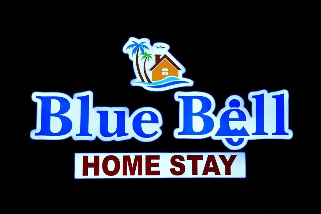a blue ball home stay sign with a house on a beach at Blue Bell Homestay in Udupi