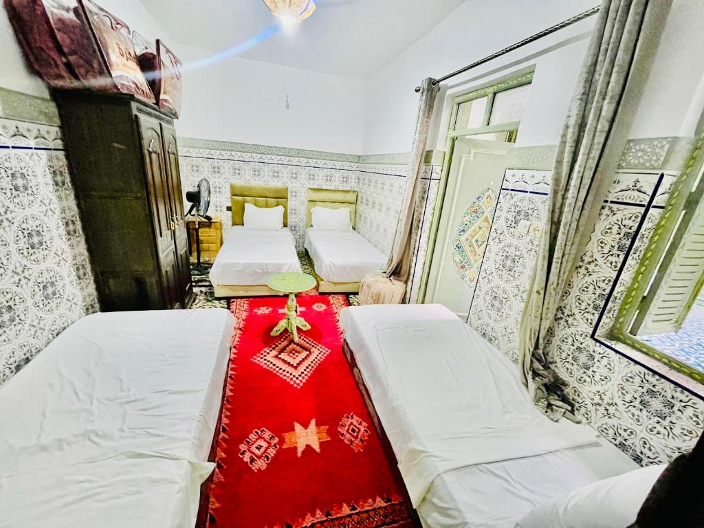 A bed or beds in a room at Riad Dar Lokman