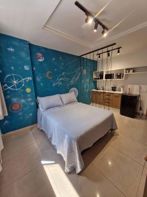 a bedroom with a bed with a painting on the wall at Studio Orion in Rio de Janeiro