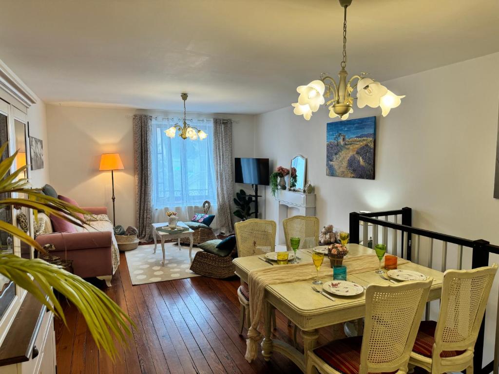 una sala da pranzo e un soggiorno con tavolo e sedie di La Marquise duplex 2 chambres avec terrasse privée by BoookingFuté a Socourt