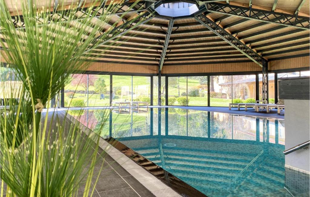 an indoor swimming pool in a house with a palm tree at Nice Apartment In Saint-Affrique in Saint-Affrique