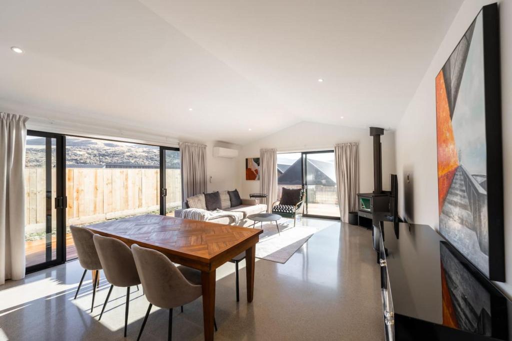 a living room with a wooden table and chairs at Amazing Retreat in Queenstown in Frankton Wharf