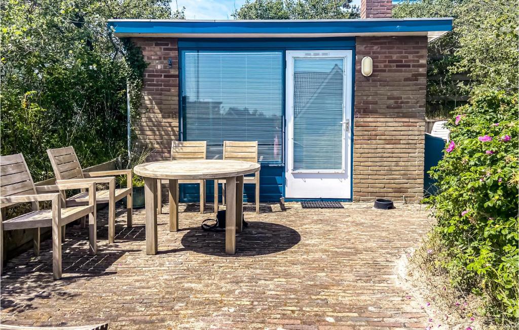 Un patio con una mesa y sillas frente a un edificio. en Poseidon 3, en Bergen aan Zee