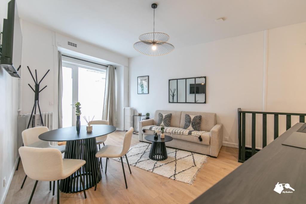 un salon avec une table, des chaises et un canapé dans l'établissement MBA - Boulangers Splendide Appartement, à Paris