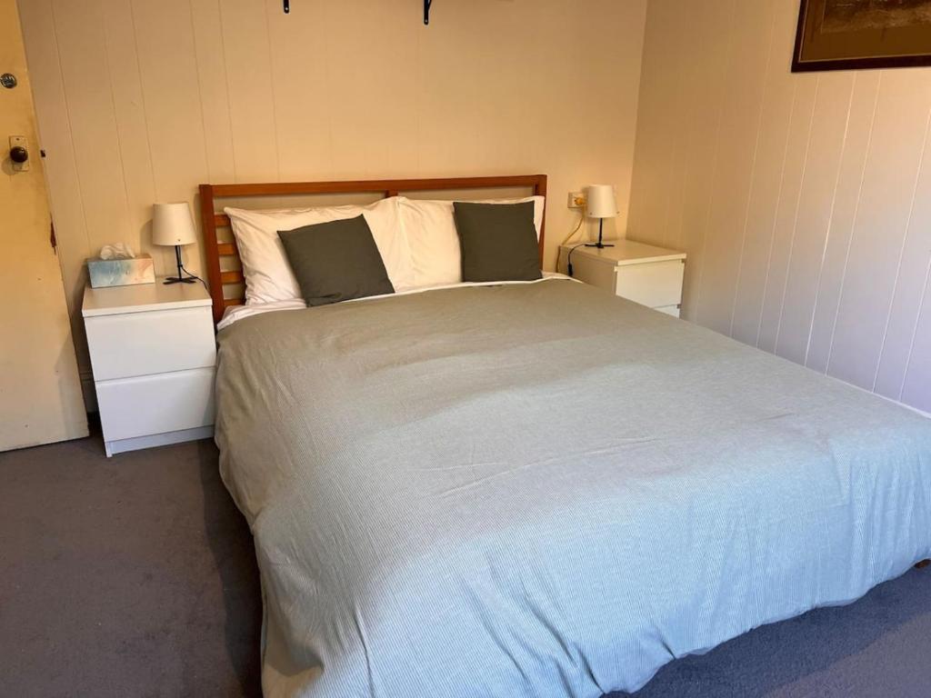 Un dormitorio con una cama grande con dos mesitas de noche. en Alkira Cottage - Cozy, Comfortable, and Convenient, en Katoomba