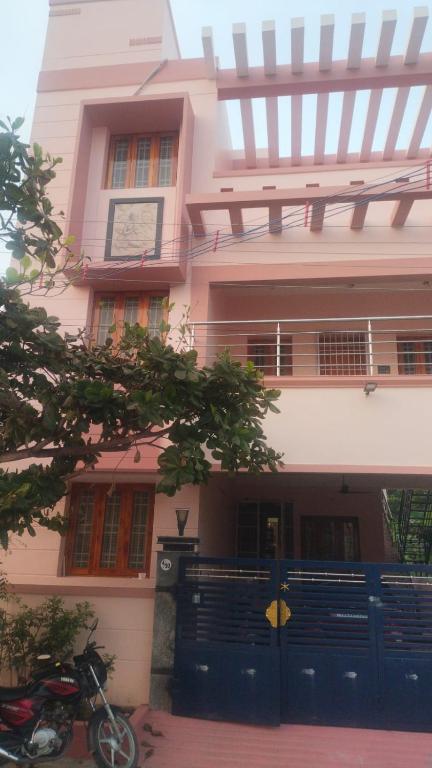 a house with a blue gate and a motorcycle parked in front at Sri Krishna's AC in Tiruvannāmalai