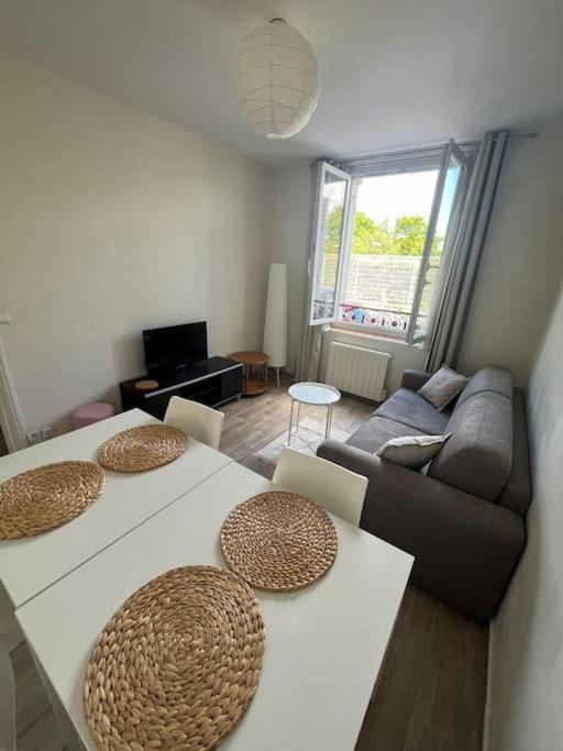 - un salon avec deux tables et un canapé dans l'établissement GoodGuest- Cosy appartement Clichy, à Clichy