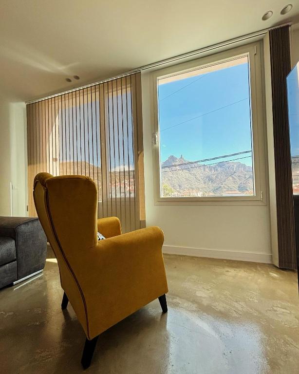 a living room with a chair and a large window at Ventana del Nublo 1D in Tejeda