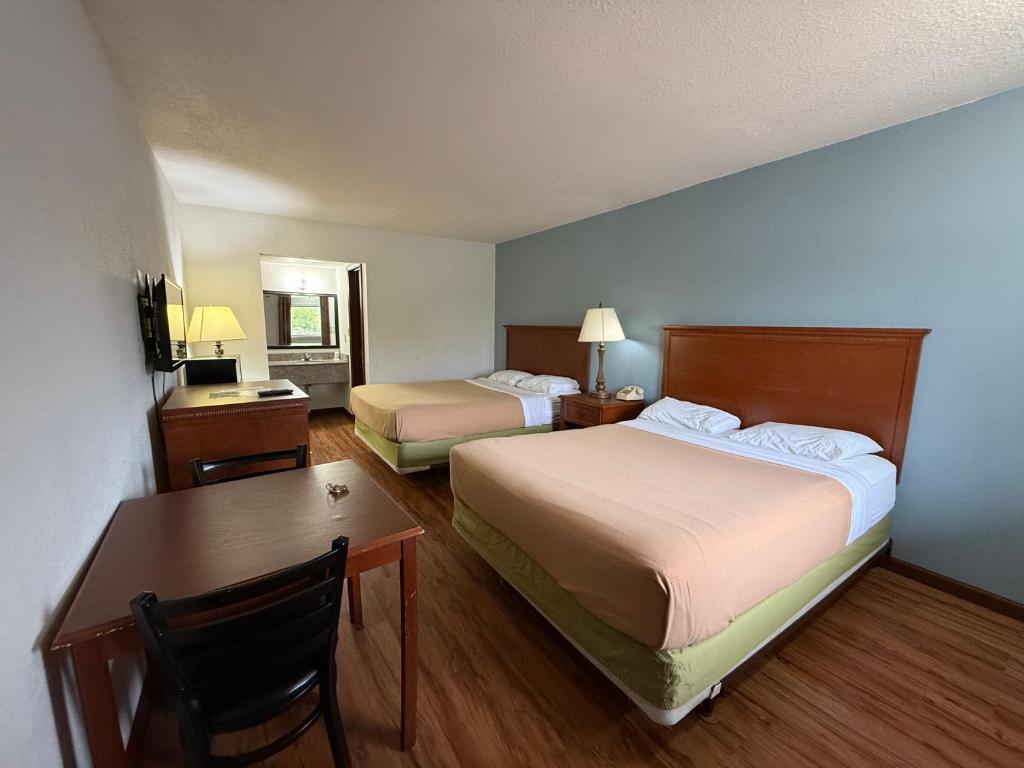 a hotel room with two beds and a desk at Relax Inn & Suites in Mattoon